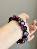 Lepidolite bracelet on wrist, silver butterfly charm adds detail, water-metal energy builds gentle aura