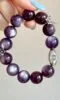 Flatlay of lepidolite bracelet, silver oval charm and flower pendant match, water-metal energy shows warm texture