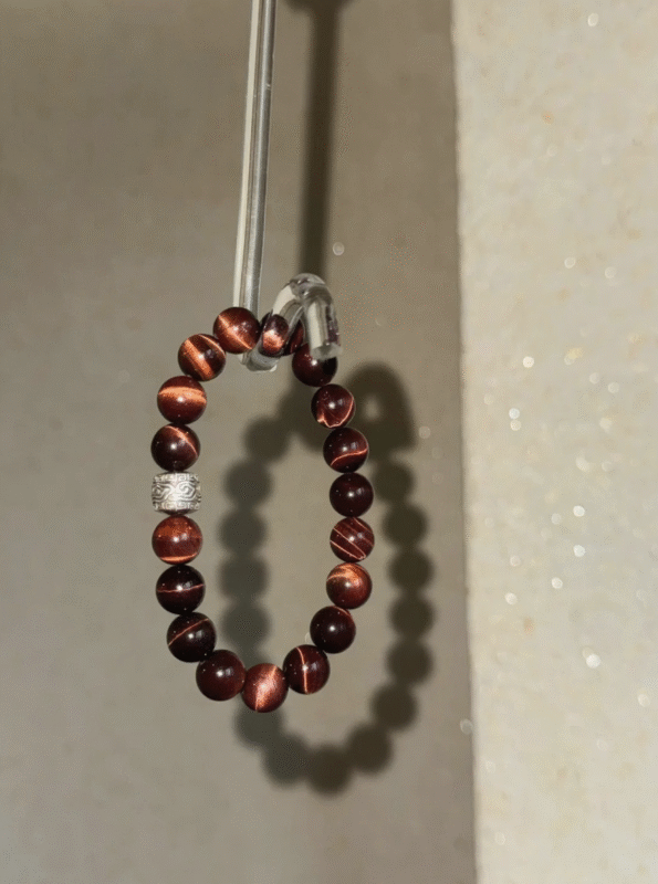 Red tiger’s eye on display! Tiger stripes glow in light, silver charm details on point