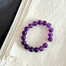 Amethyst bracelet on display, light dancing through crystals, water-metal energy unlocking spiritual aura