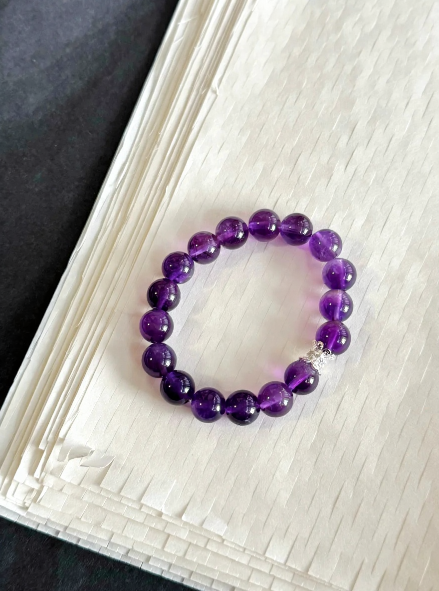 Amethyst bracelet on display, light dancing through crystals, water-metal energy unlocking spiritual aura