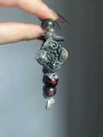 Design close-up of Jiangzi bracelet, silver carvings & multi-stones, earth-fire-metal energy in knots