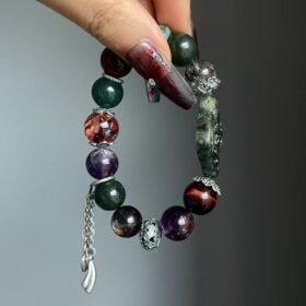 Holding Jiangzi bracelet with tassel, red rutile & silver fringe, earth-fire-metal energy building aura