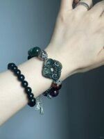 Close-up of Jiangzi bracelet, carved Xiu jade & purple phantom, earth-fire-metal energy in patterns