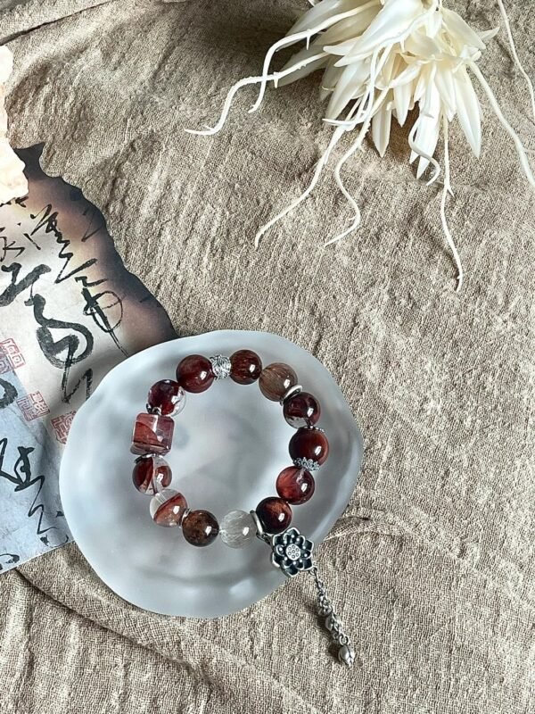 Red rutile bracelet on wrist, red copper hair & black gold super seven layered, fire-metal synergy showing personality