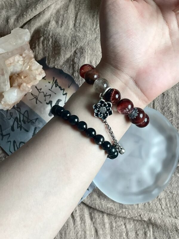 Layered red rutile multi-stone bracelet, red tiger’s eye with silver tassel, fire-metal energy on wrist