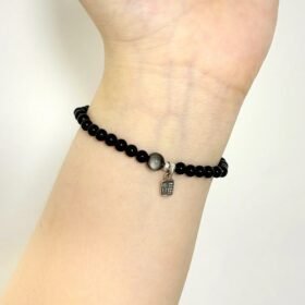 Obsidian bracelet on wrist, delicate bead design, water-metal energy building protection aura