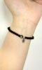 Obsidian bracelet on wrist, delicate bead design, water-metal energy building protection aura