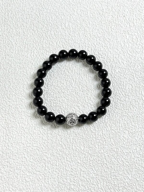 Close-up flatlay of obsidian bracelet, black beads matching silver, water-metal synergy hiding mystery