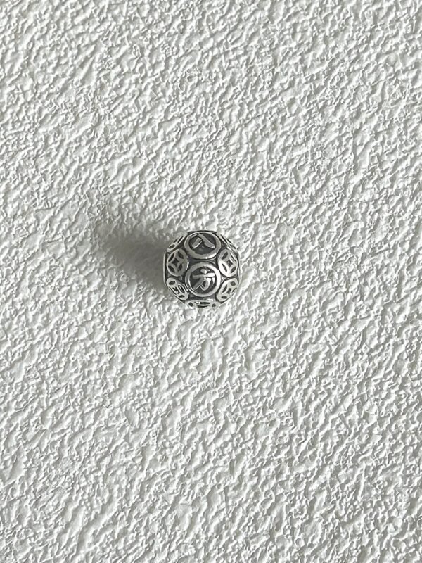 Another angle of silver carved bead, hollow design showing craft, metal-element energy building aura