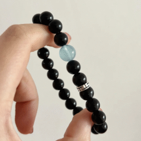 Comparison of aquamarine & obsidian beads, blue-black contrast hiding mystery, water-metal energy in knots
