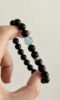 Comparison of aquamarine & obsidian beads, blue-black contrast hiding mystery, water-metal energy in knots