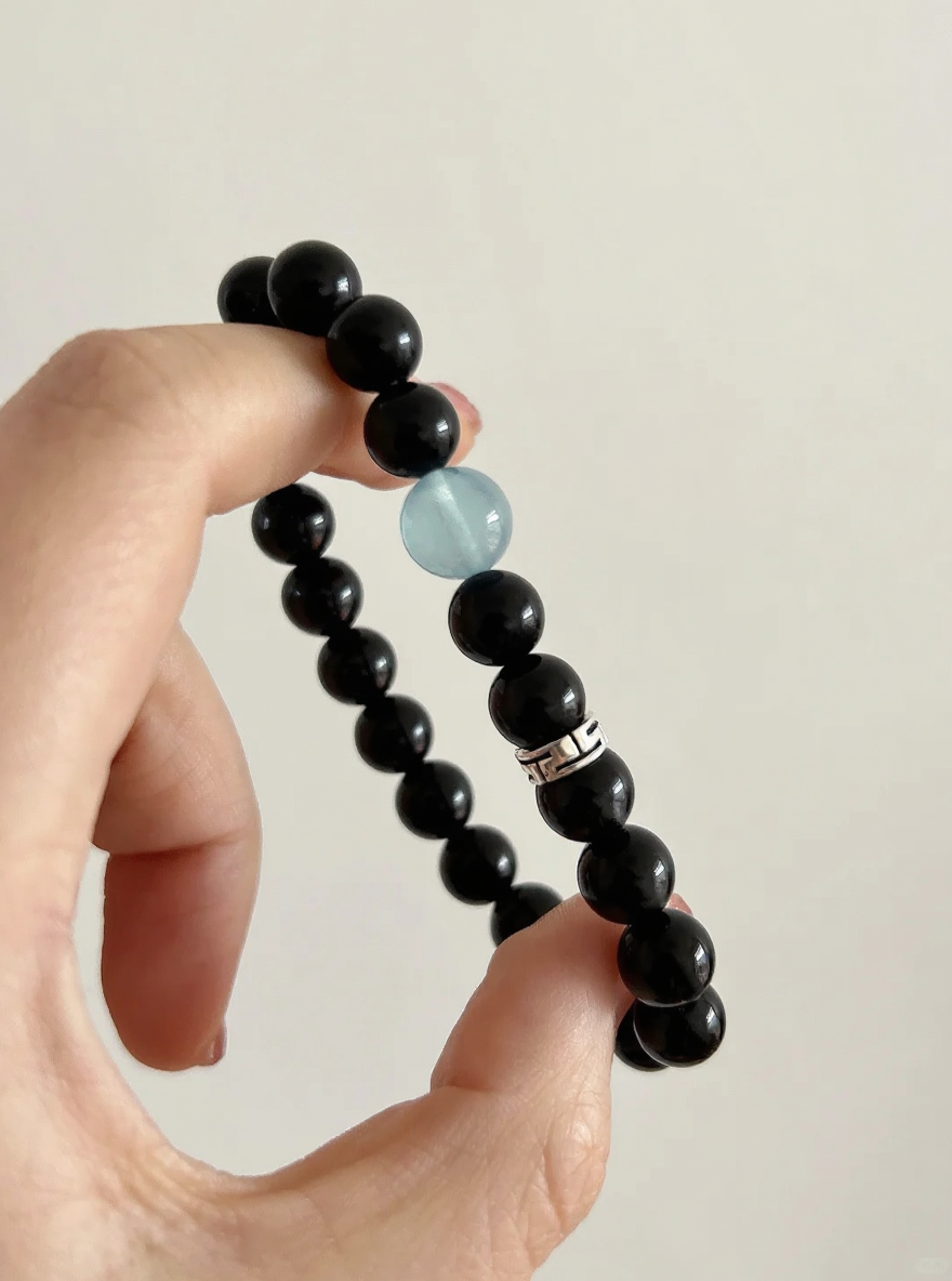 Comparison of aquamarine & obsidian beads, blue-black contrast hiding mystery, water-metal energy in knots