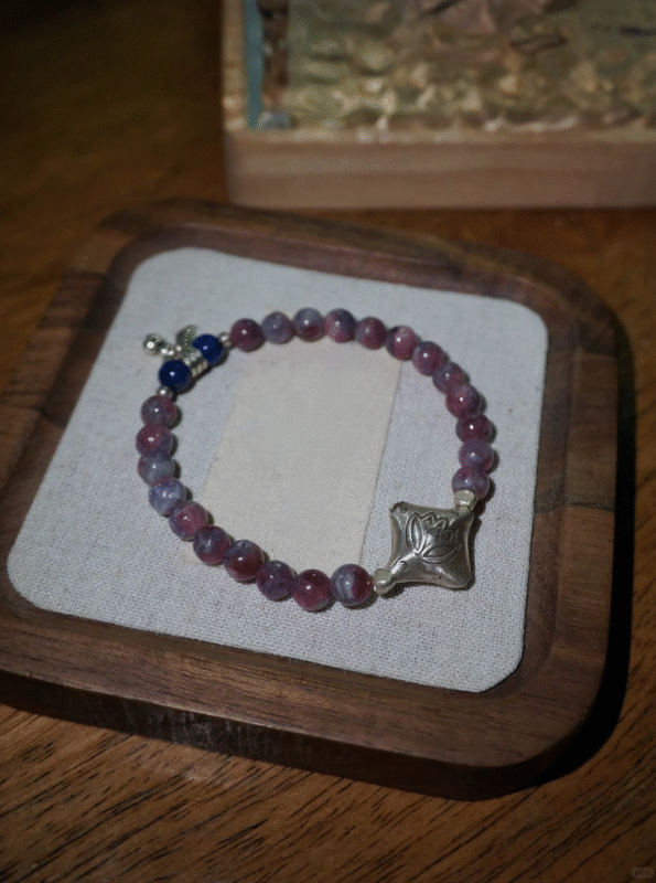 Plum tourmaline bracelet on square tray, lapis lazuli spacers show layers, fire-wood-metal energy in knots