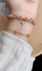 Layered orange moonstone bracelet, gold star charm & blue moonstone beads, fire-metal energy brightens skin