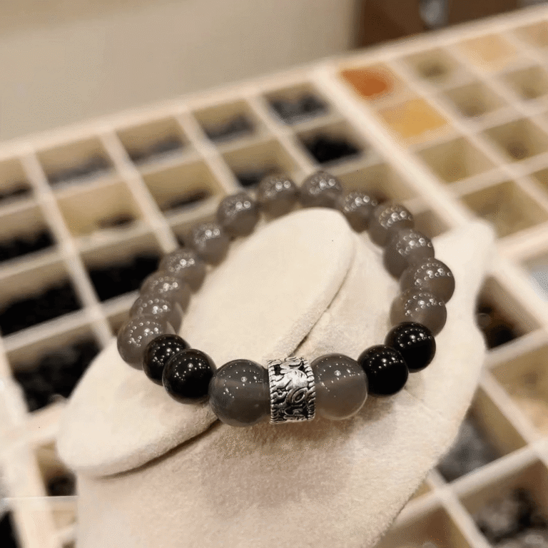 Close-up of gray agate bracelet, silver patterns twist with gray-black beads, water-metal energy shows texture
