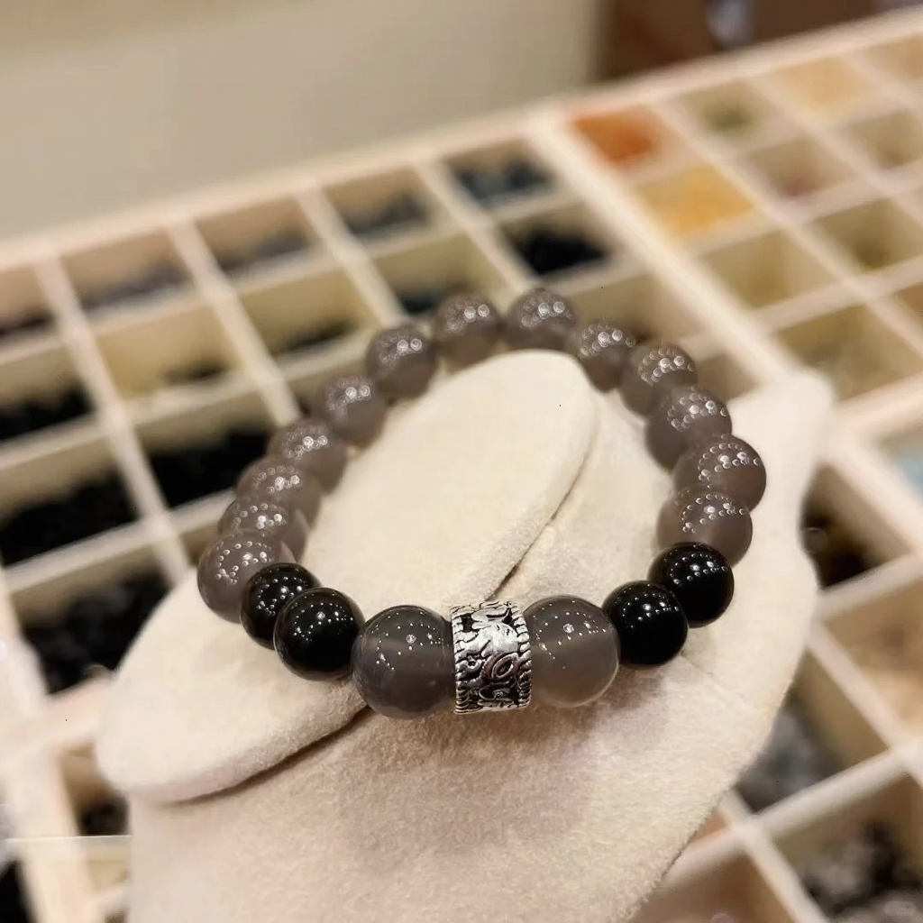 Close-up of gray agate bracelet, silver patterns twist with gray-black beads, water-metal energy shows texture