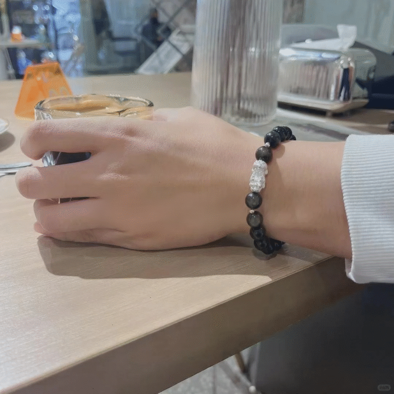 Golden obsidian bracelet on wrist, holding coffee for daily look, 999 silver pixiu gathers water-metal energy