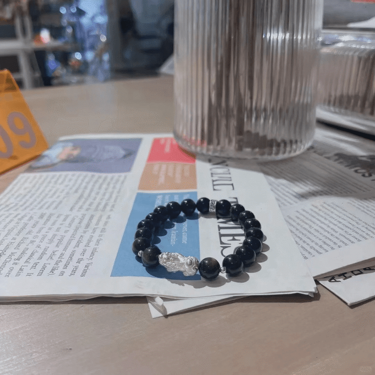 Golden obsidian men’s bracelet on newspaper, 999 silver pixiu charm, water-metal energy for wealth