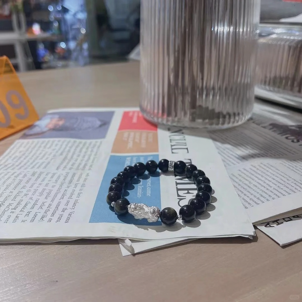 Golden obsidian men’s bracelet on newspaper, 999 silver pixiu charm, water-metal energy for wealth