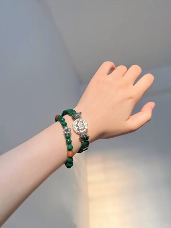 Layered malachite double-strand, silver elephant charm in center, wood-fire-metal energy in knot design