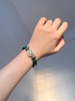 Malachite bracelet on wrist, red agate spacers add layers, wood-fire-metal energy in vintage charm