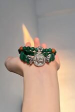 Malachite bracelet against fire background, green beads match silver, wood-fire-metal energy holds mystery