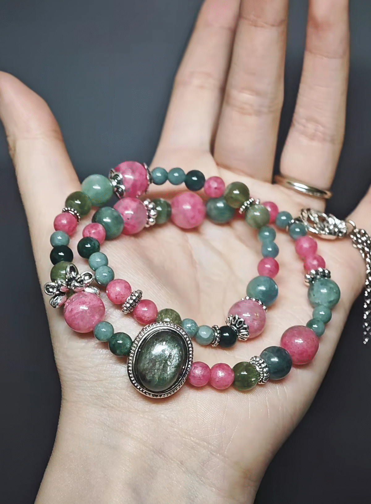 Dynamic display of the bracelet, resonating Fuchsite growth and Rhodonite passion