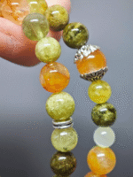 Wearing a multi-strand bracelet with 13pcs 8mm Tsavorite Garnet, 6pcs 6mm Tsavorite Garnet, 12pcs 9mm Yellow Fire Quartz, 1pc Yellow Fire Quartz cube, 11pcs 8mm Yellow-Green Xiu Jade, 3pcs 7mm White Hetian Jade, showcasing fire-earth-metal energy fusion