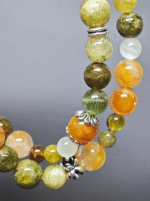 Multi-strand bracelet displaying color layers of Tsavorite Garnet, Yellow Fire Quartz, Xiu Jade, Hetian Jade, highlighting fire-earth synergy