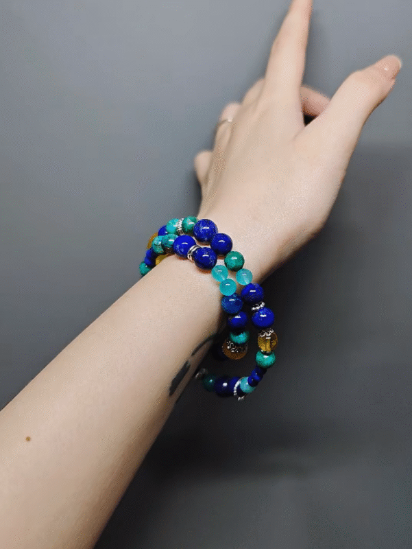 Wearing a multi-strand bracelet with a Yellow Fluorite cushion, 9mm Yellow Fluorite, 8mm Yellow Fluorite, 15pcs 8mm Lapis Lazuli, 9pcs 6mm Lapis Lazuli, 5pcs 7mm Amazonite, 12pcs 8mm Chrysocolla Pine, 6pcs 8mm Blue Apatite, showcasing water-wood-earth-metal energy fusion