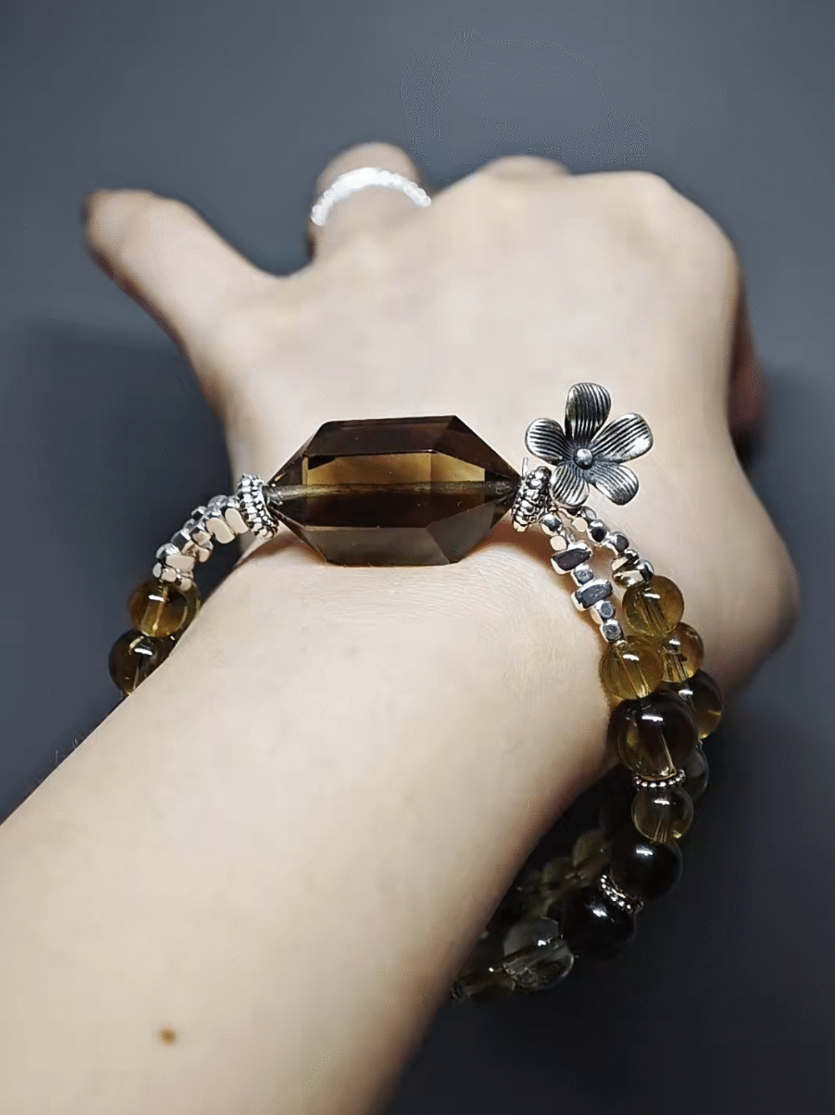 Wearing a double-strand bracelet with a Smoky Quartz double-terminated point, 9pcs 8mm Smoky Quartz, 10pcs 8mm Tea-Yellow Citrine, 13pcs 6.5mm Tea-Yellow Citrine, adorned with silver flower clasp, showcasing earth-metal energy fusion