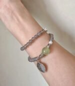 Wearing a double-strand bracelet with 8mm Gray Agate, 10mm Xiu Jade, and 6mm White Shell, showcasing earth-wood-water energy fusion