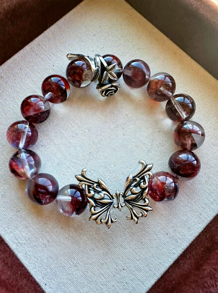 Design detail of Blood Red Fire Quartz bracelet, fire-metal protection of silver butterfly & rose