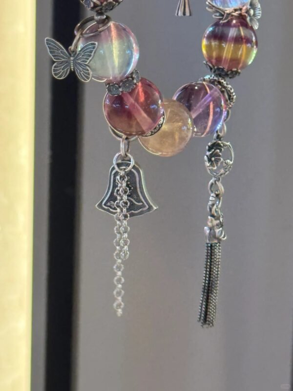 Close-up of silver accents on Rainbow Fluorite bracelet, bell totem’s color-metal rhythm