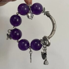 Close-up of 19mm Amethyst bracelet with silver half-hoop, butterfly & bell totems, water-metal energy resonance