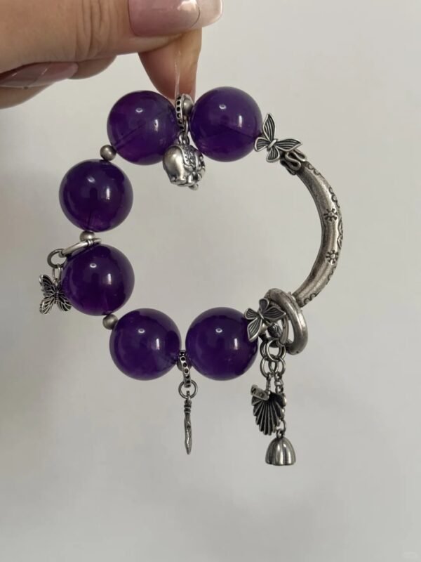 Close-up of 19mm Amethyst bracelet with silver half-hoop, butterfly & bell totems, water-metal energy resonance