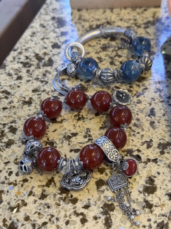 Close - up of 16mm/18mm Red Agate and Blue Crystal bracelets, with silver accents showing fire - metal energy resonance