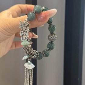 Design close-up of jadeite bracelet, silver totems resonating with beads, earth-metal harmony