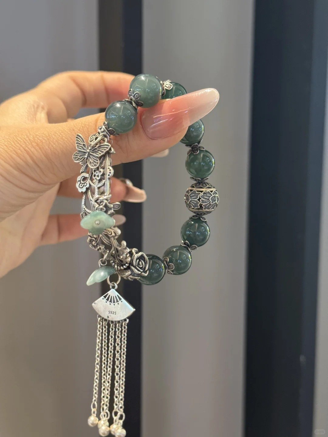 Design close-up of jadeite bracelet, silver totems resonating with beads, earth-metal harmony