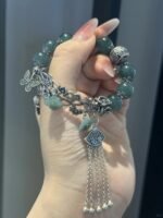 Detail of jadeite bracelet, silver rose intertwined with beads, earth-metal synergy