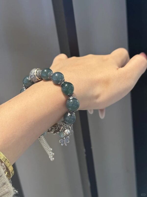 Wearing jadeite bead bracelet with silver butterfly and tassels, earth-metal energy emerging