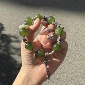 Hand detail of Green Grape Xiu Jade bracelet, silver totems’ wood-metal secrets