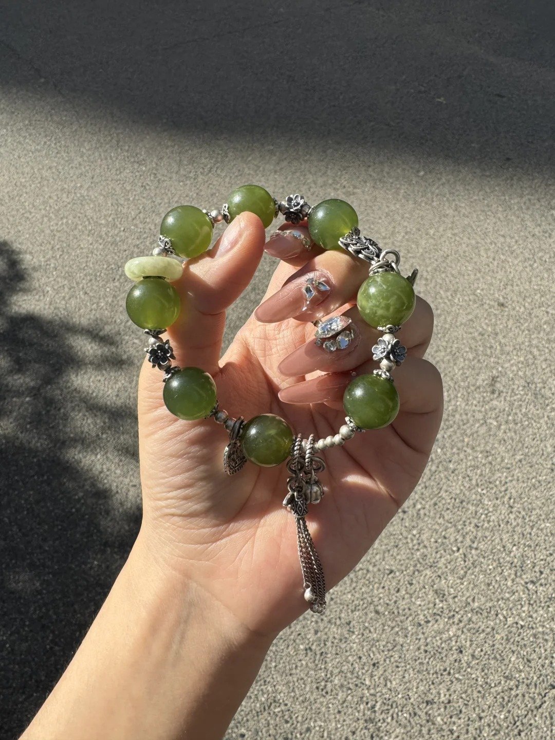 Hand detail of Green Grape Xiu Jade bracelet, silver totems’ wood-metal secrets