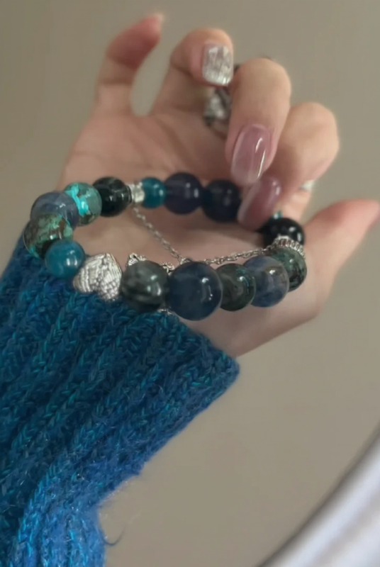Mirror view of multi-gem bracelet, symmetric blue-metal balance